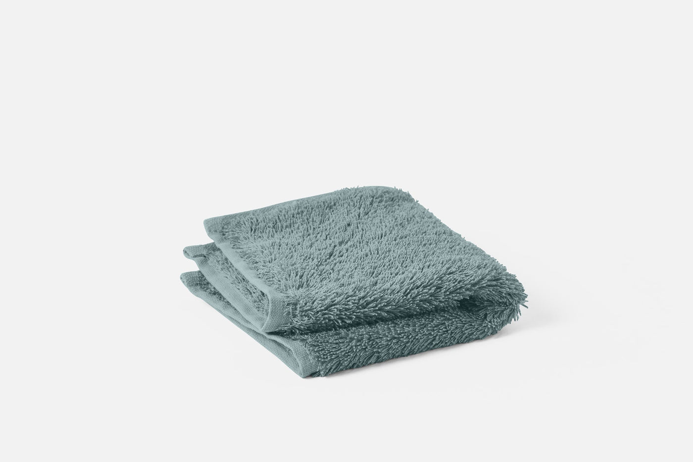 Coyuchi Cloud Loom wash cloth folded in sage, showing plush terry loop texture.