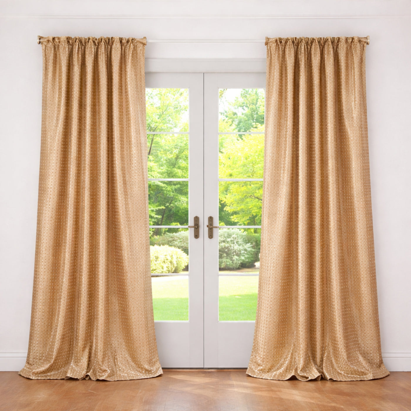 Gold Ann Gish Coin curtain panels draped floor-to-ceiling beside French doors overlooking a garden.