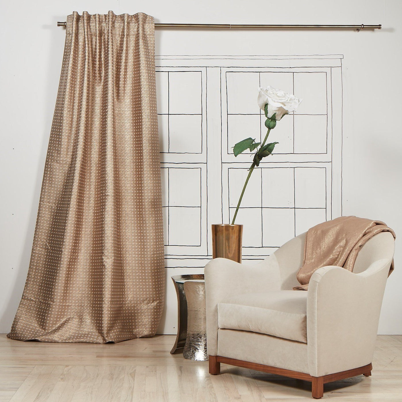 Ann Gish Coin curtain panel in champagne, textured dot pattern, styled beside armchair.