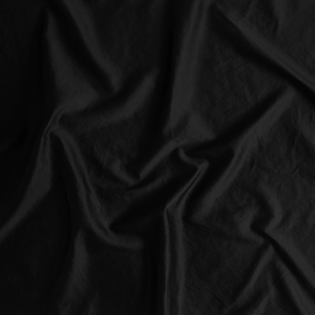 Close-up of draped Corvino linen fabric showing soft folds and matte sheen.