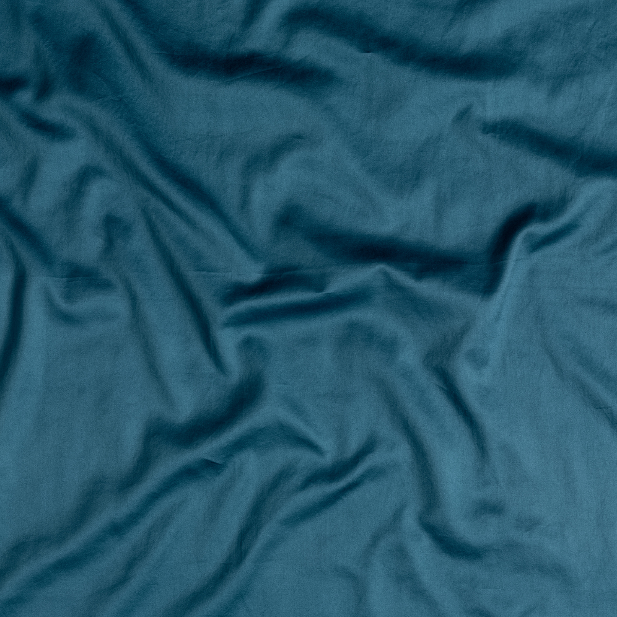Close-up of Bella Notte Bria flat sheet in Cenote, showing draped linen fabric texture.