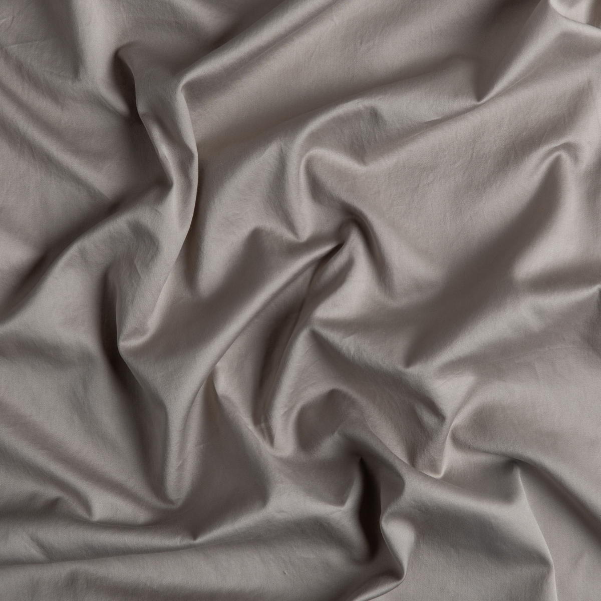 Close-up of Bella Notte Bria flat sheet in Fog, showing draped sateen fabric with soft folds.
