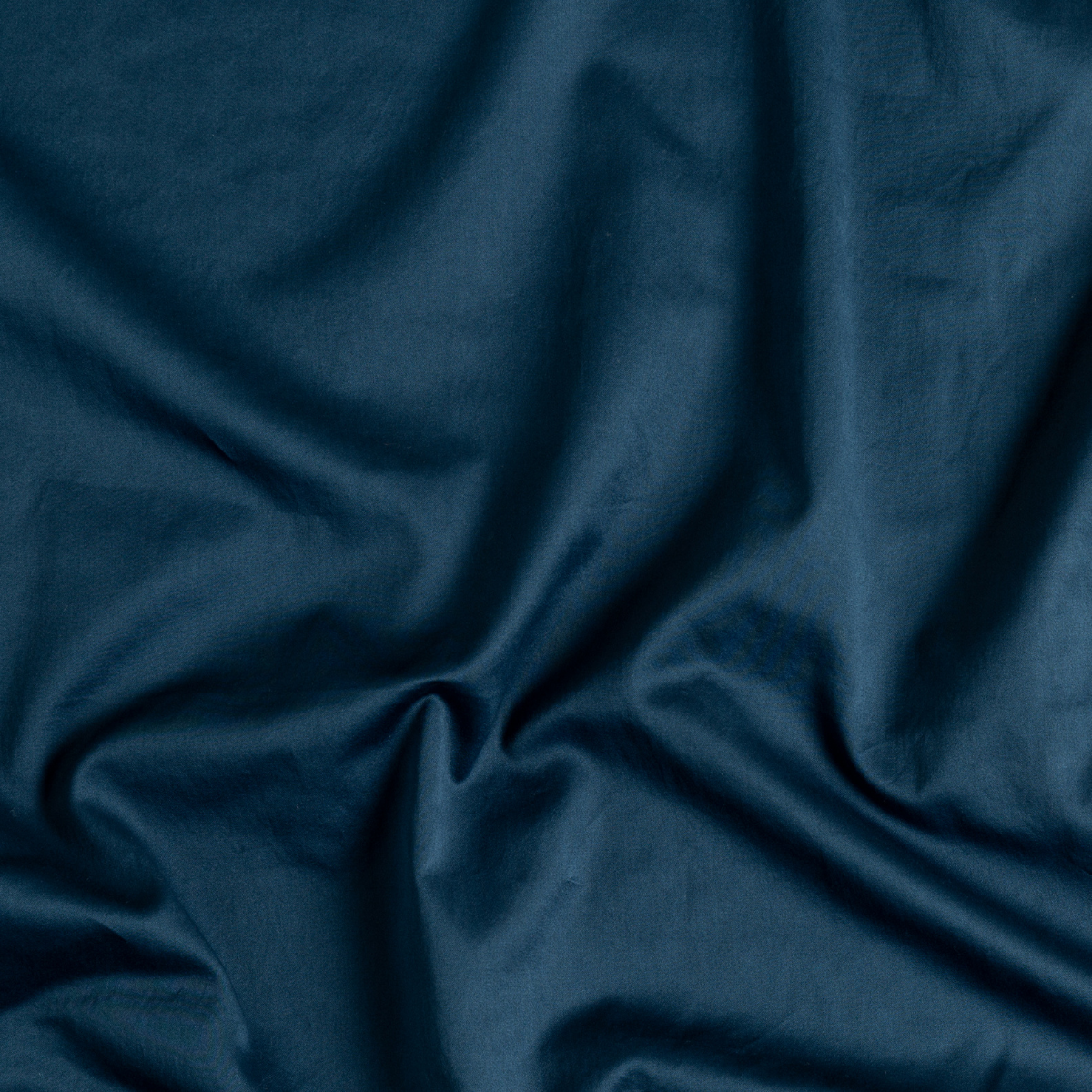 Midnight flat sheet fabric draped to show smooth cotton texture and deep teal tone.