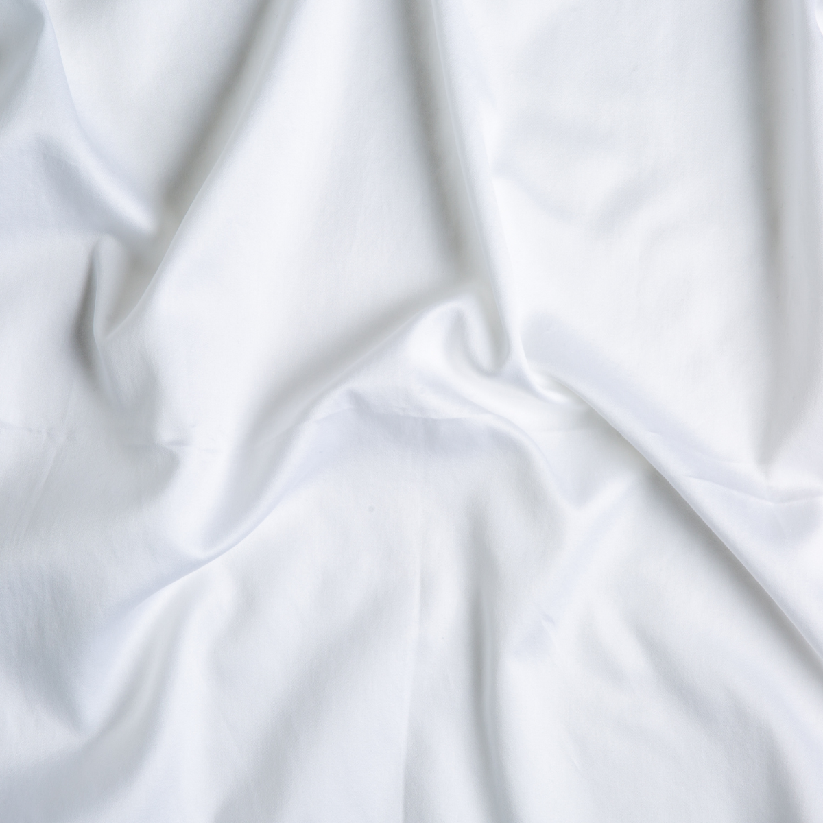 Close-up of draped White Bella Notte Bria pillowcase fabric showing smooth, fluid folds.