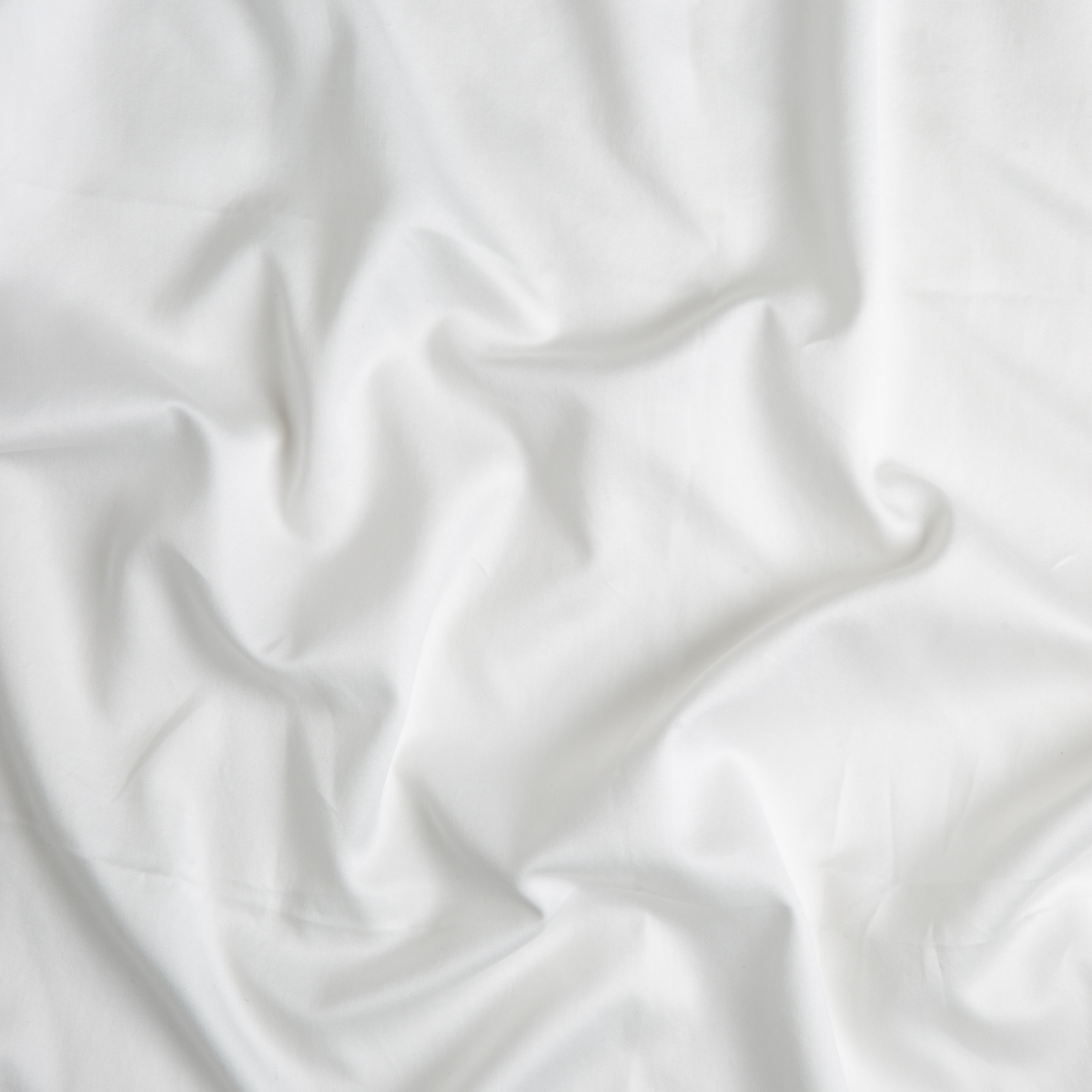 Close-up of Winter White Bella Notte Bria flat sheet fabric showing soft draping and smooth weave.