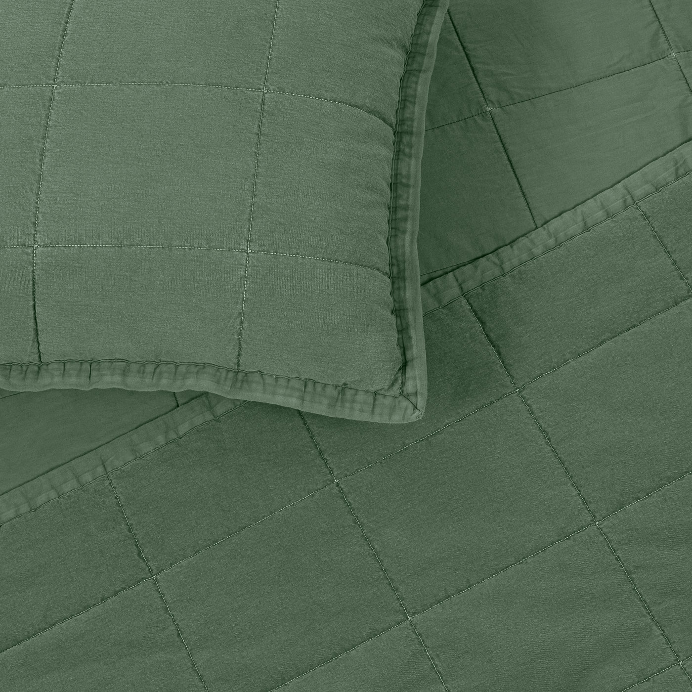 Close-up of sage green quilted cotton coverlet with diamond stitching and matching sham corner.