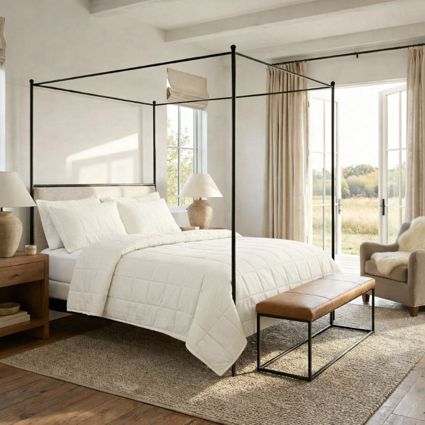 Ivory cotton coverlet set on four-poster bed in sunlit neutral bedroom.