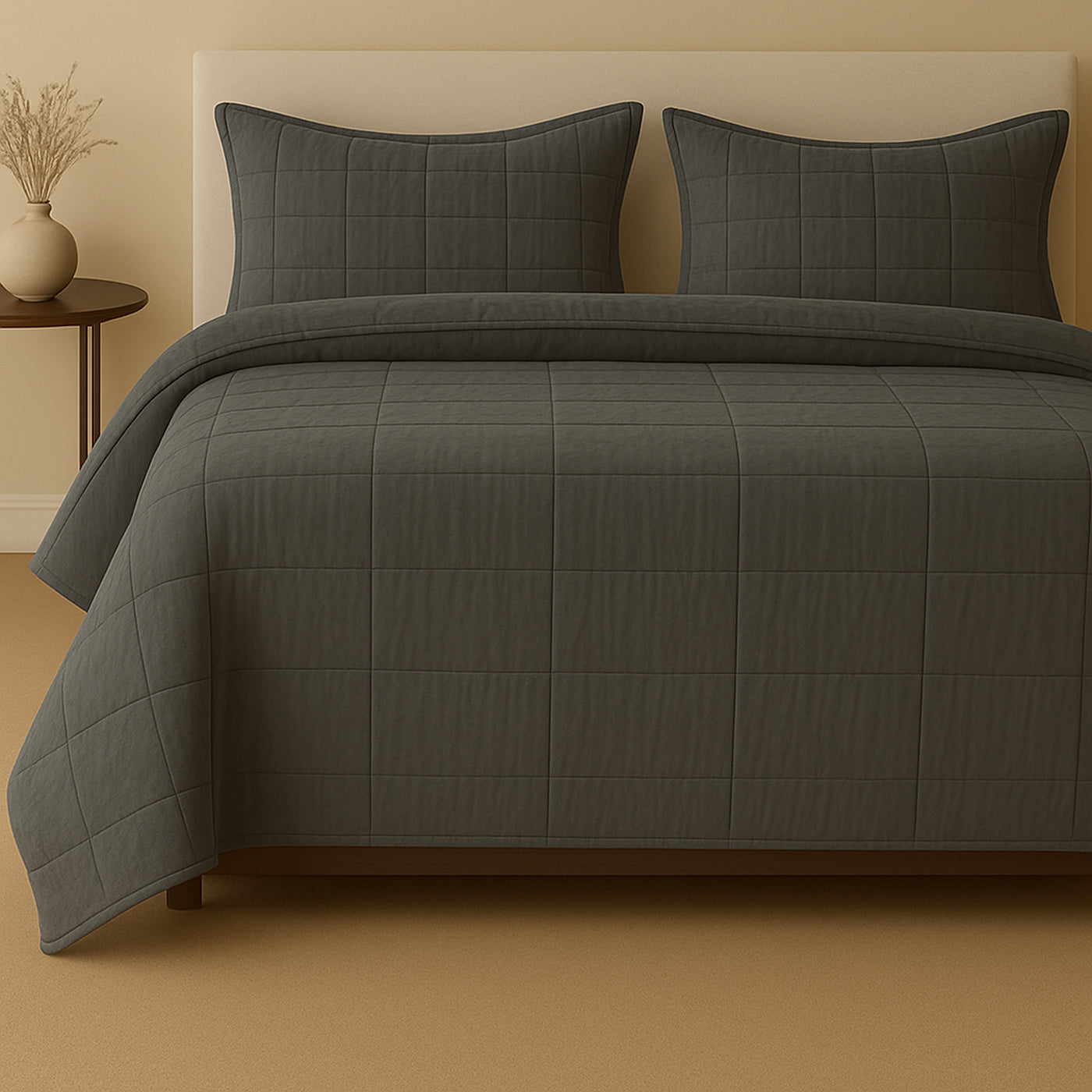 Charcoal quilted coverlet set styled on a bed with matching shams, grid stitch pattern.