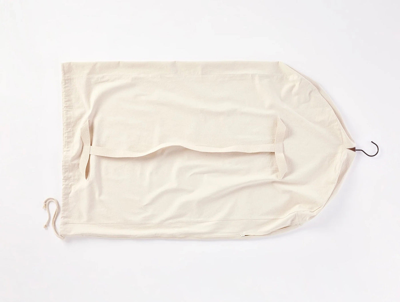 Coyuchi Conserve garment bag laid flat, natural cotton with drawstring and metal hook.