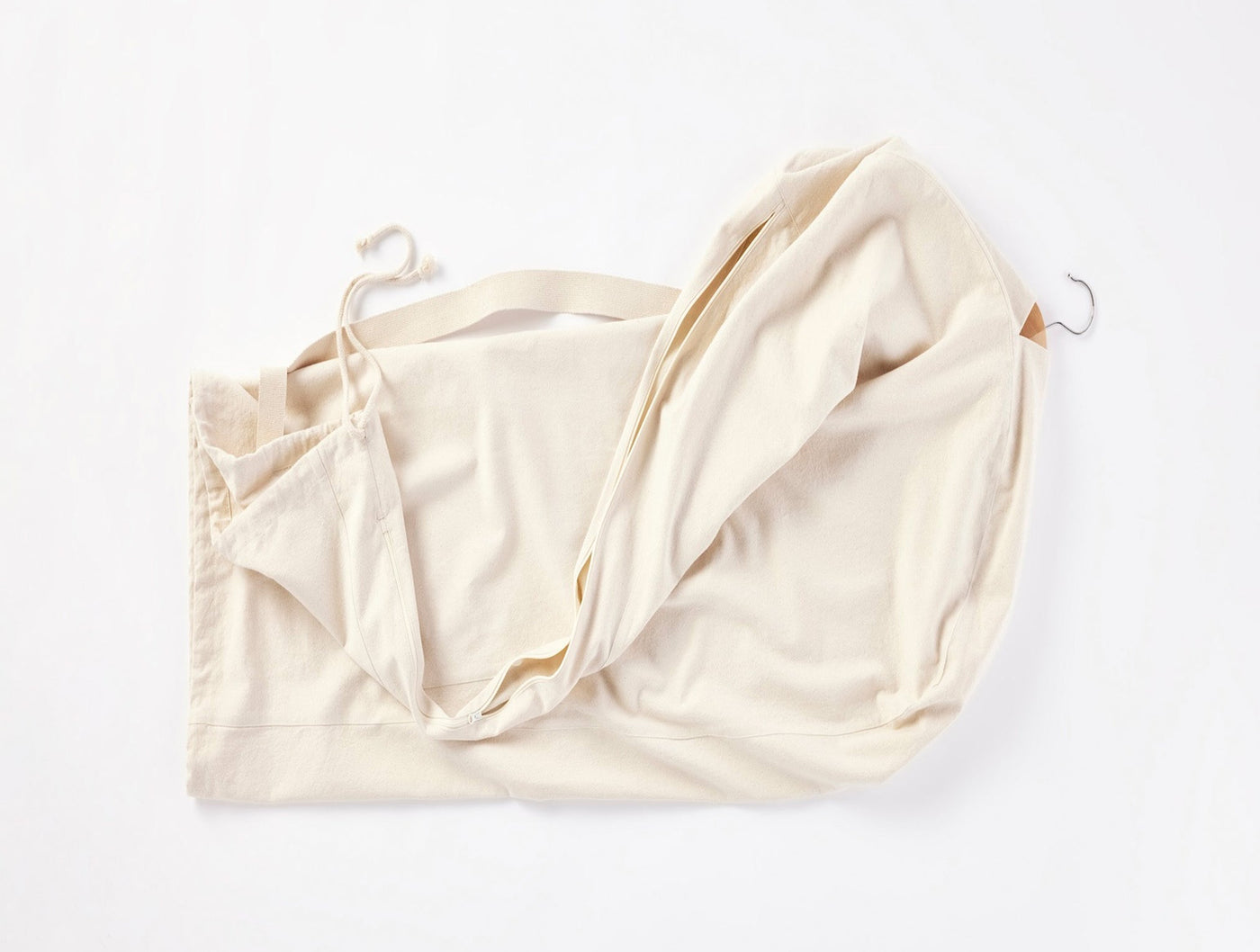 Ivory cotton garment bag with drawstring closure and metal hook, shown unfolded.