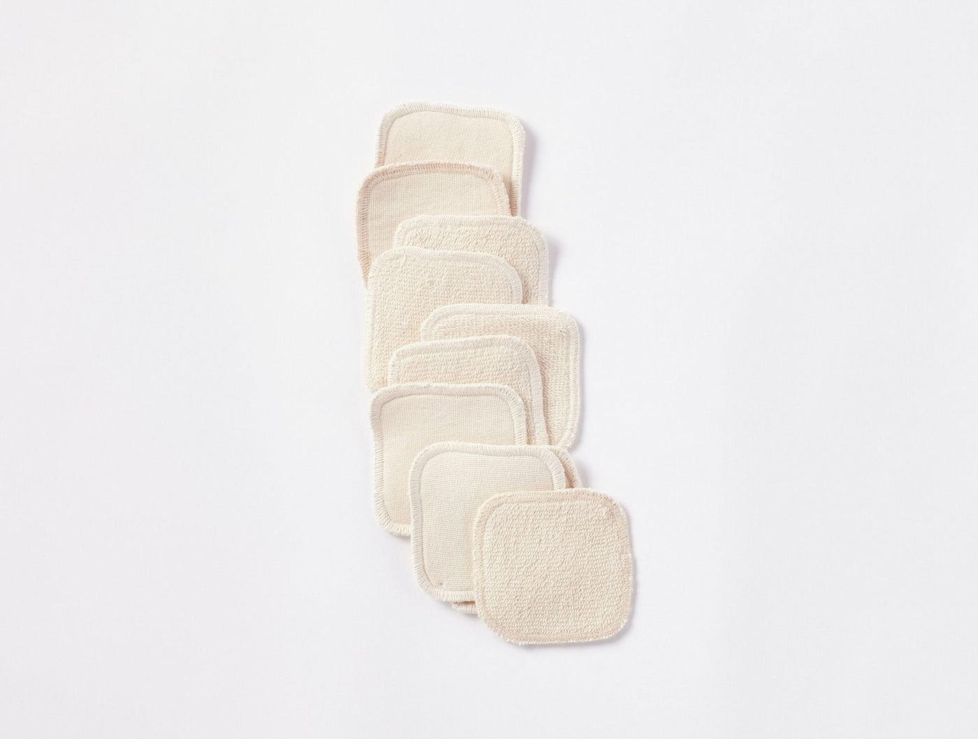 Coyuchi Bare reusable makeup pads fanned in diagonal row, natural ivory organic terry cloth.