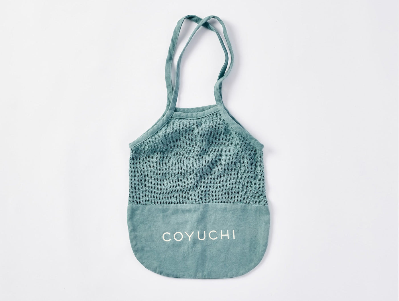 Coyuchi tote bag in sage green with white logo and textured upper panel.