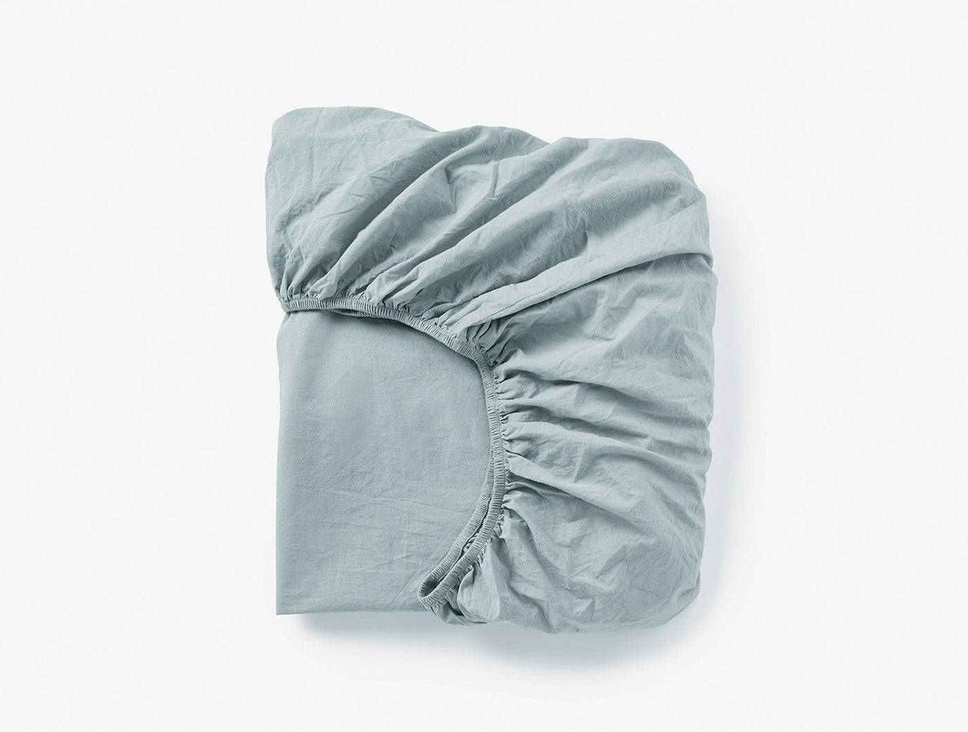 Folded sage fitted sheet showing elasticated corner detail against white background.