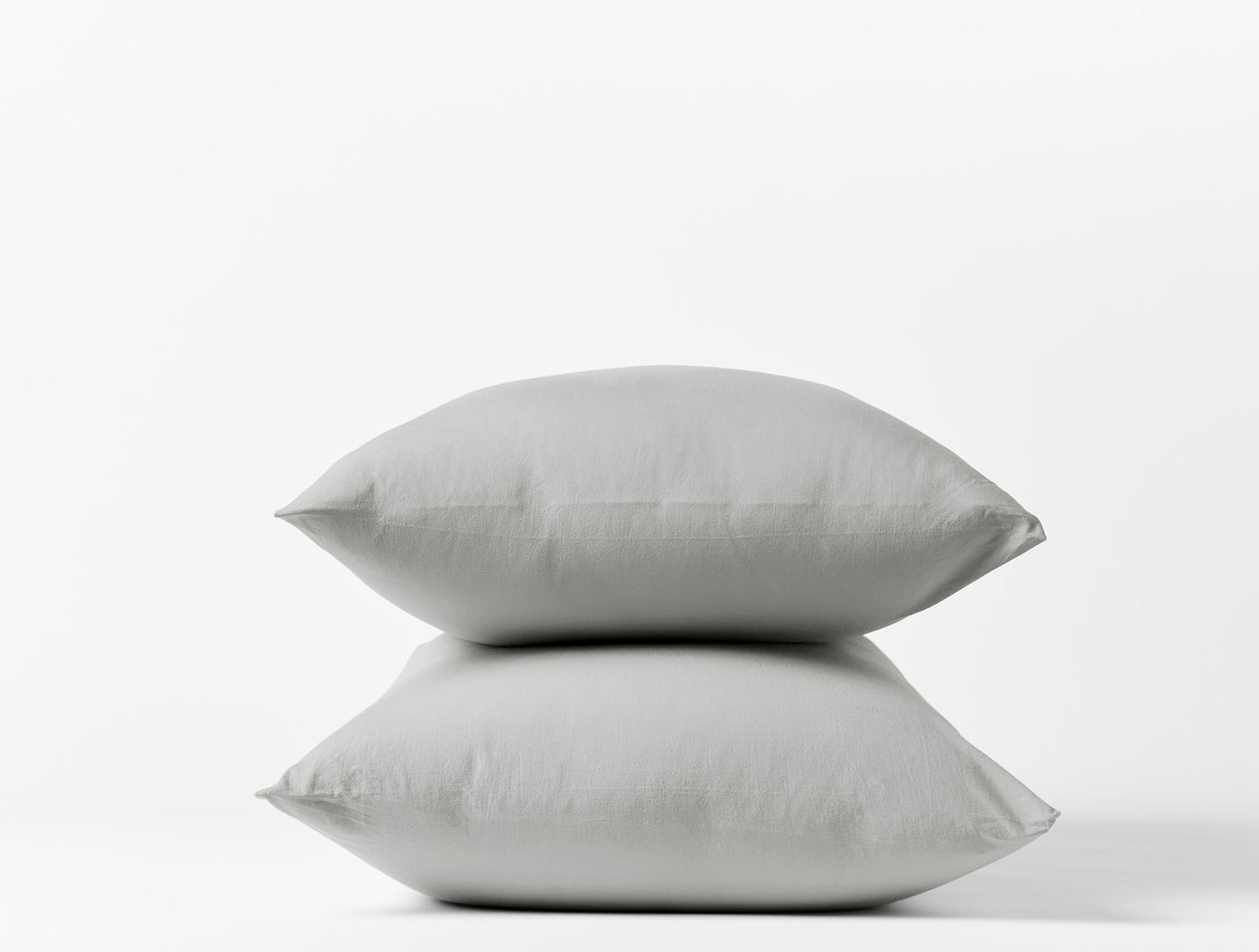 Two stacked Coyuchi Crinkled Percale pillowcases in silver grey against white background.
