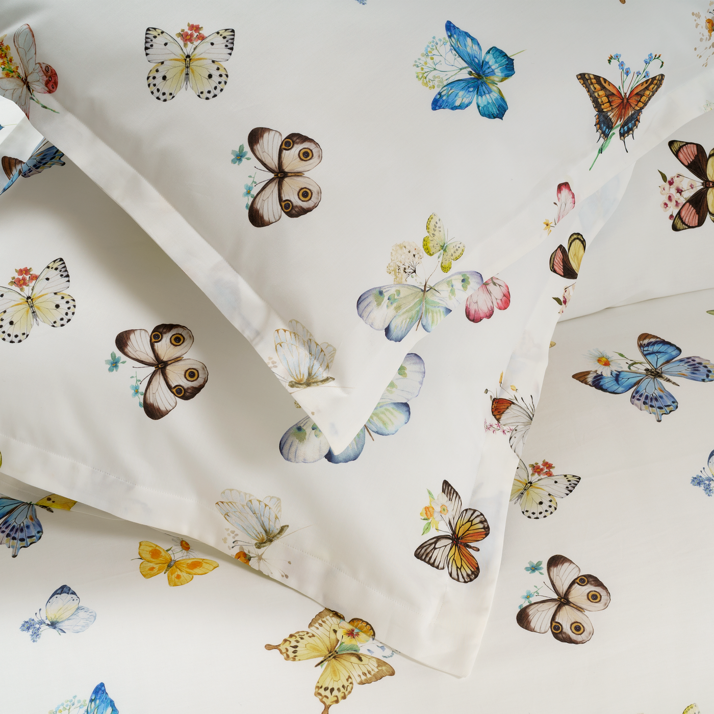 Close-up of DEA Volante duvet set showing multicolor watercolor butterfly print on ivory cotton.