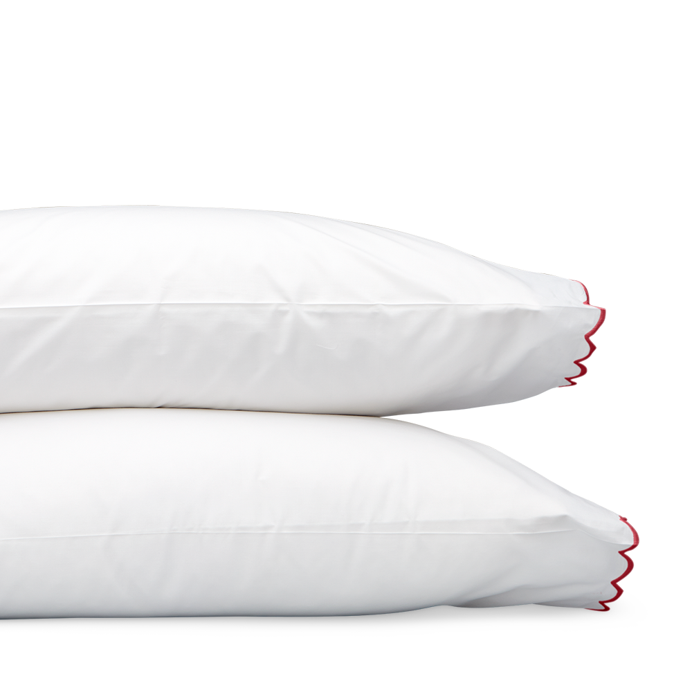 Matouk Dakota white pillowcase set with red scalloped edge trim, stacked pair.