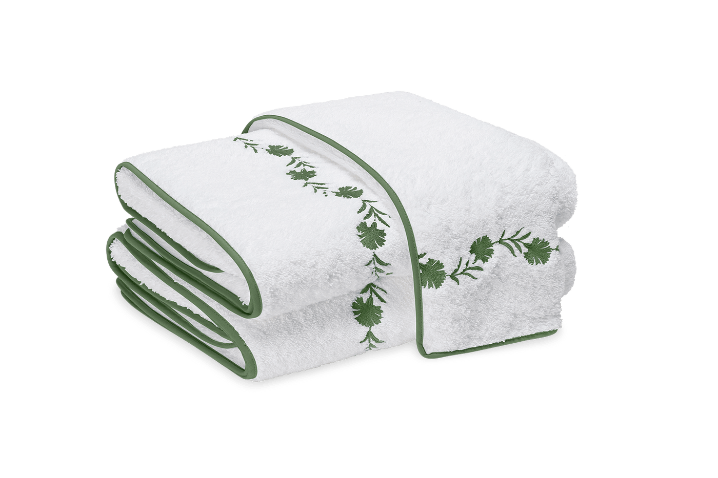 Close-up of folded white bath sheets with forest green floral embroidery and contrast border.