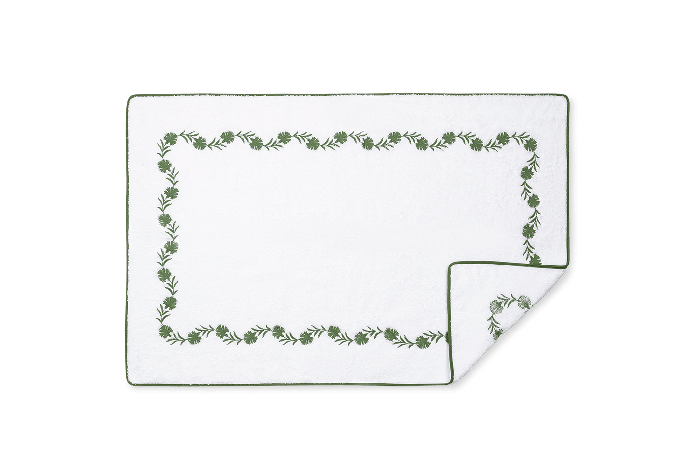Corner detail of Matouk Daphne tub mat showing green botanical embroidered border on white cotton.