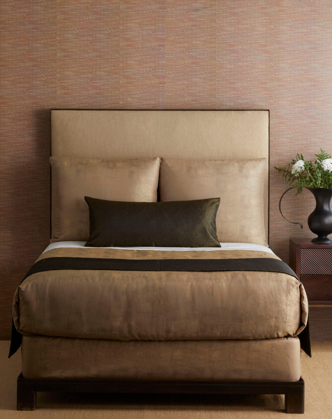 Bed styled with a dark espresso Ann Gish Dapple bed finisher across camel bedding.