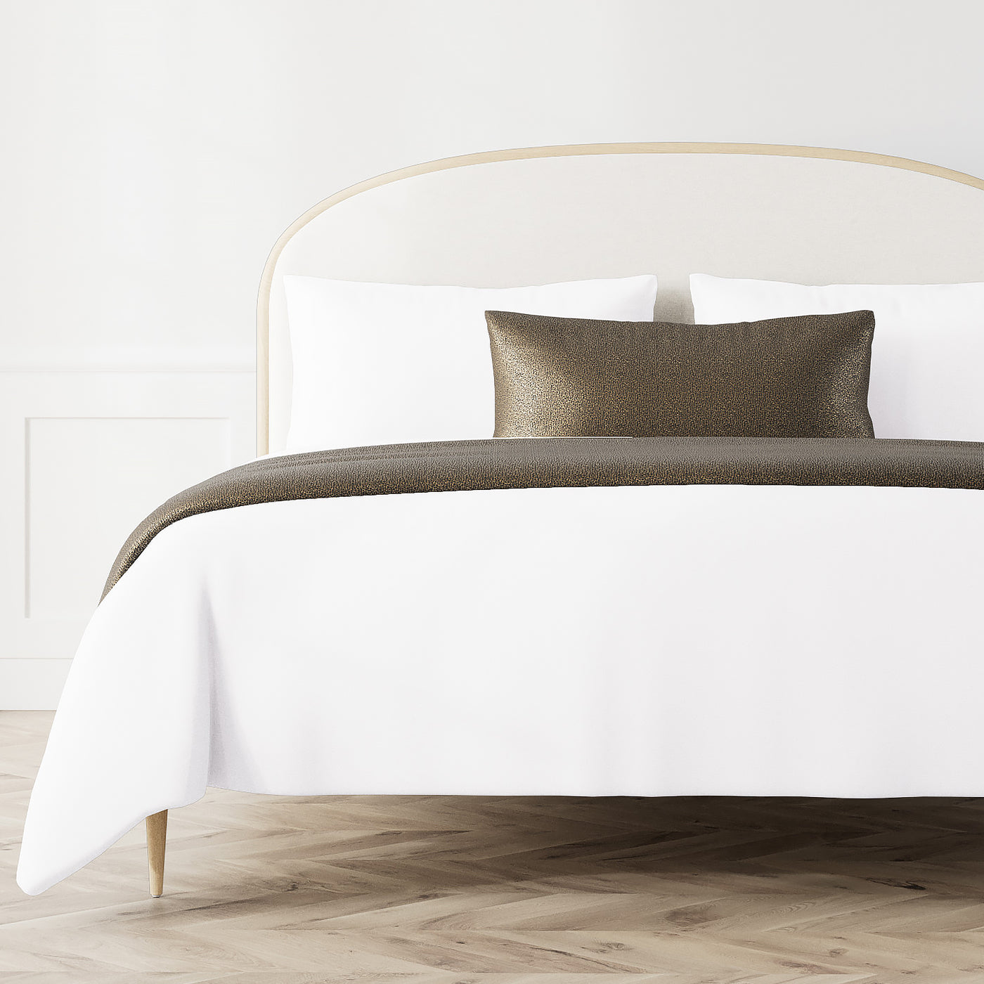 Ann Gish Dapple bed finisher in bronze styled across a white duvet on a made bed.