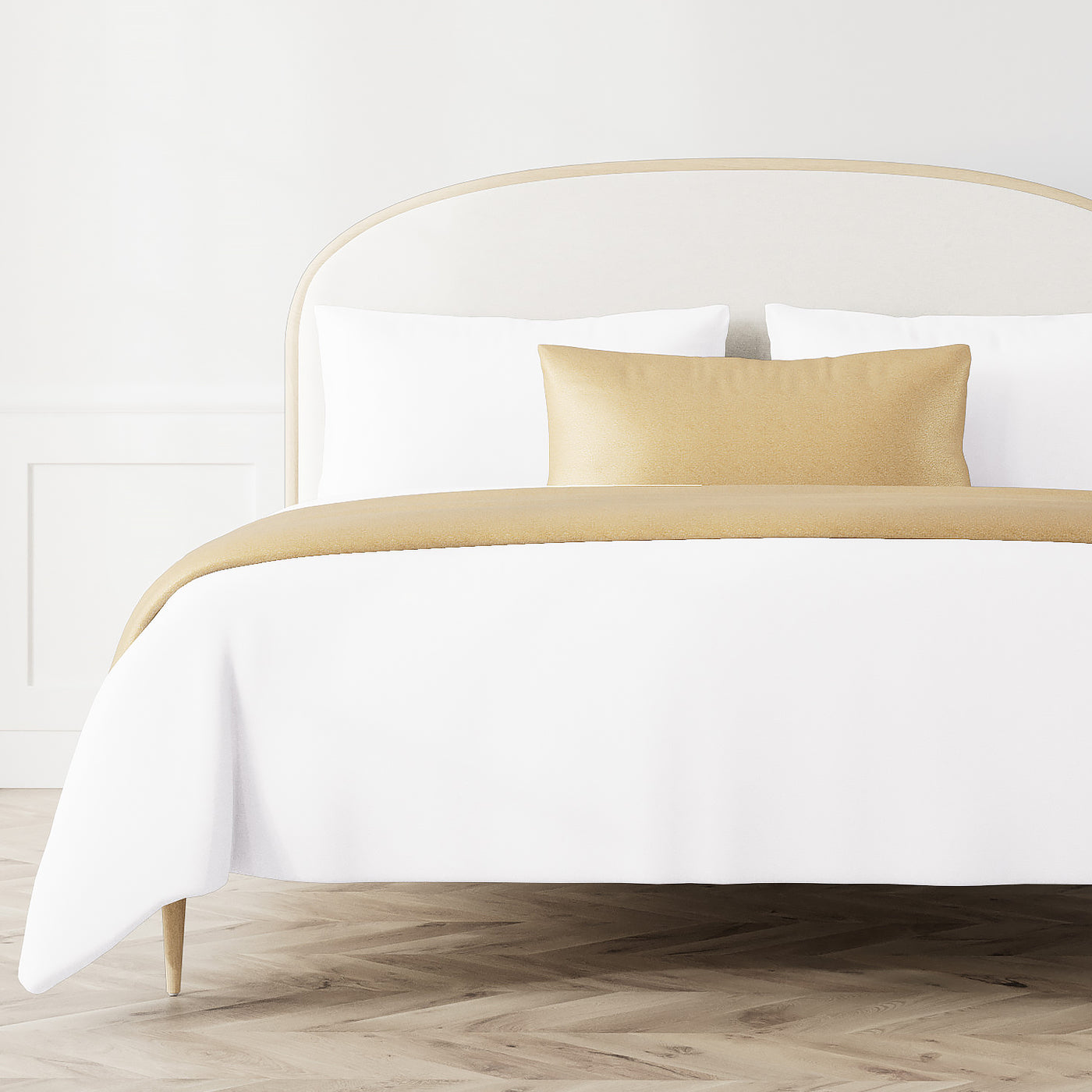 Ann Gish Dapple bed finisher in gold styled on white bedding with matching lumbar pillow.