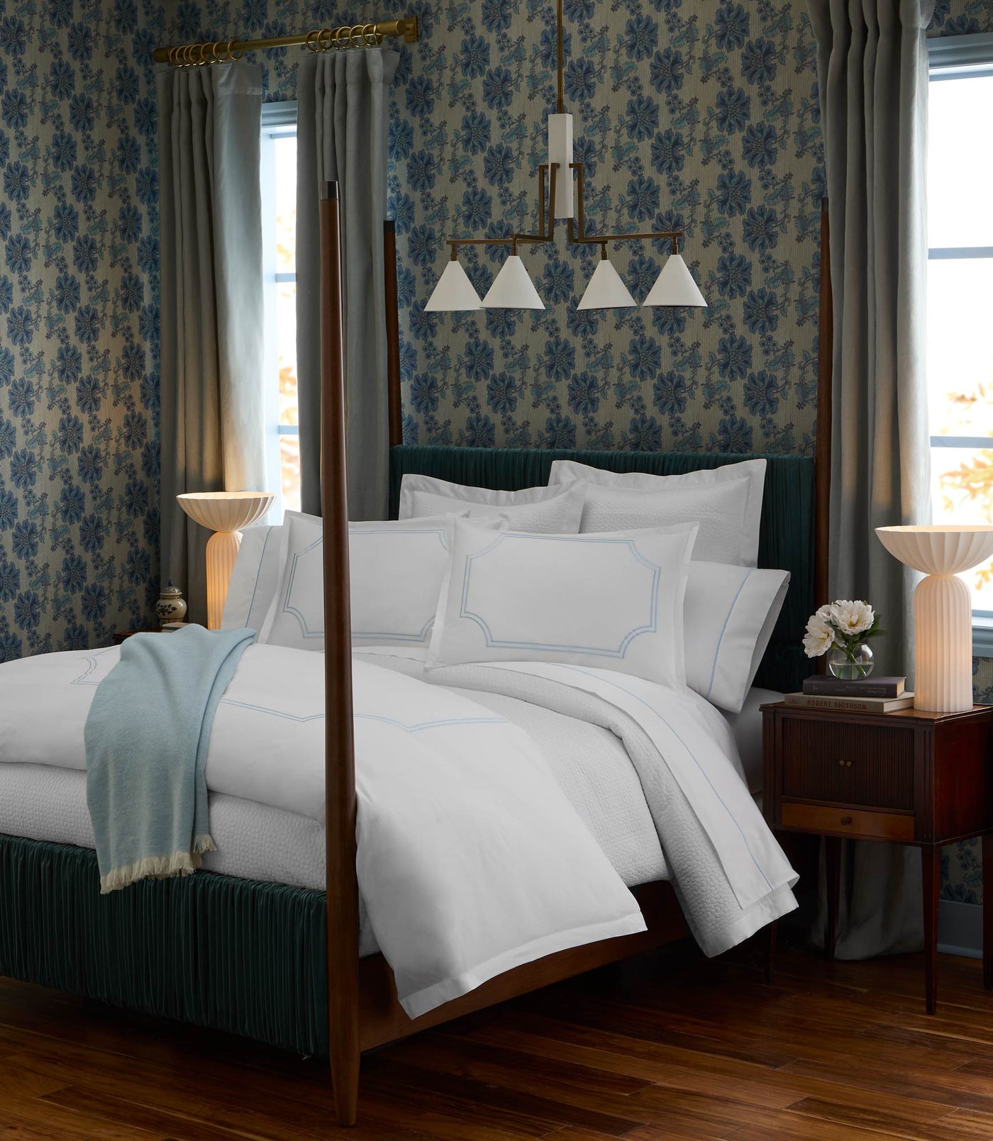 White Peacock Alley Deco duvet styled on a four-poster bed with powder blue throw accent.