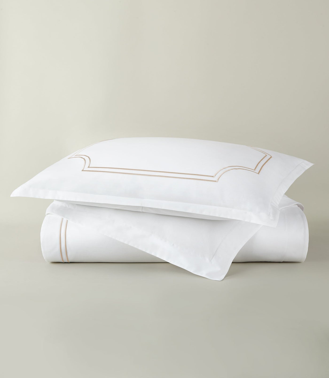 Peacock Alley Deco duvet cover set in white with champagne embroidered border detail.