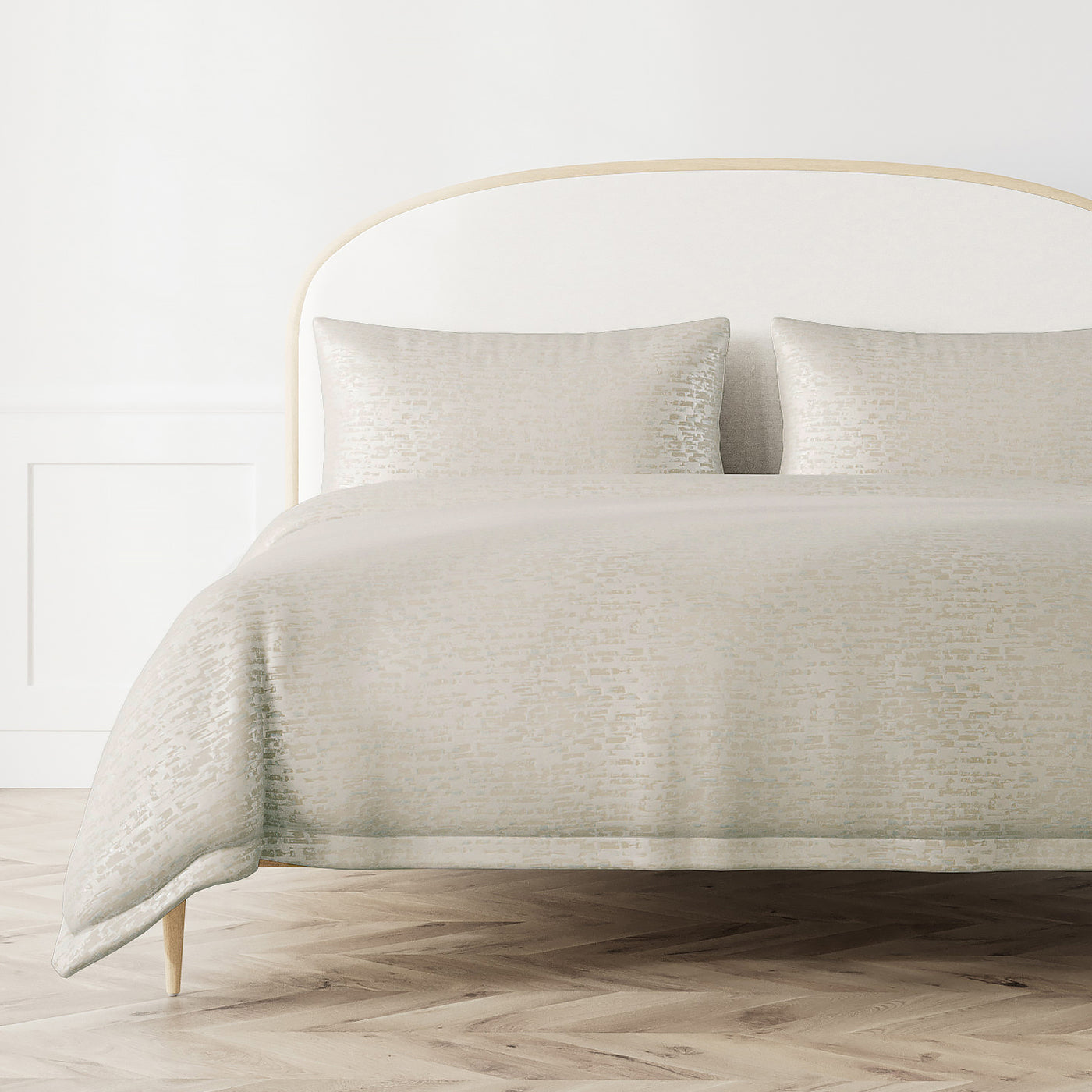 Ann Gish Delphi duvet cover in ivory with subtle textured pattern on a styled bed.