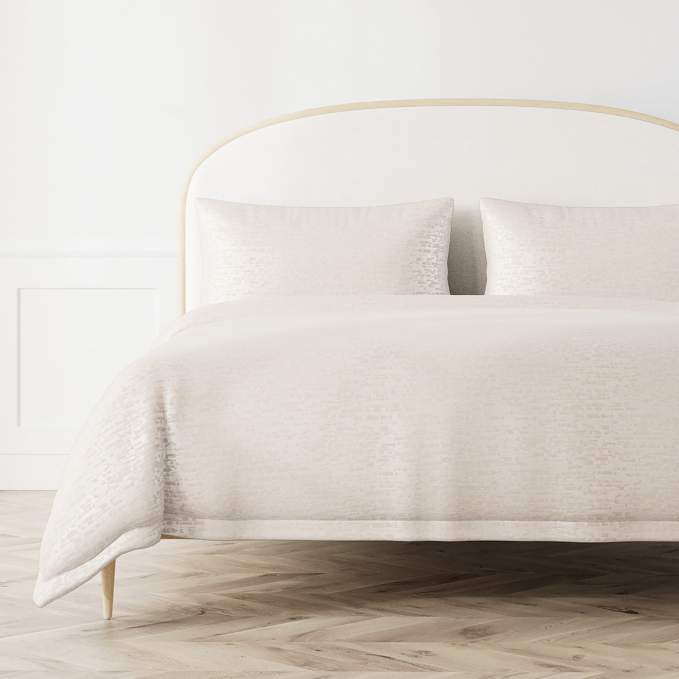 Ann Gish Delphi duvet cover in ivory styled on bed with matching shams, full bed view.