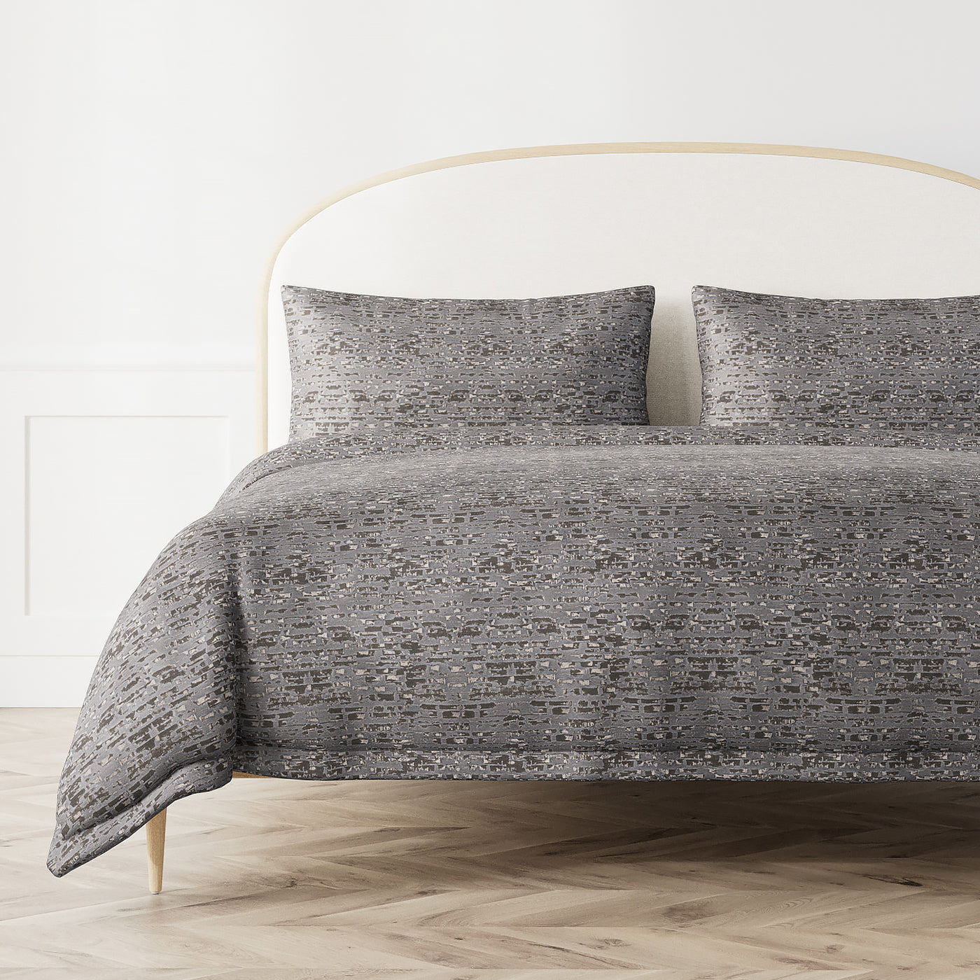 Ann Gish Delphi duvet cover in grey mosaic pattern styled on a bed with matching shams.