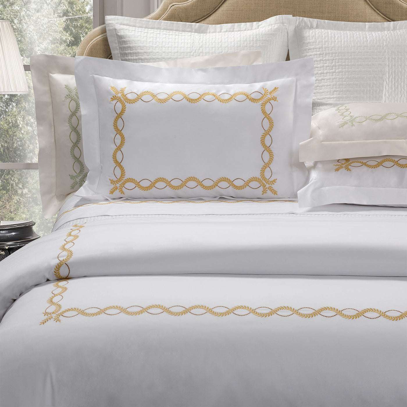 Dea Diana white duvet cover with gold and silver chain embroidered border.