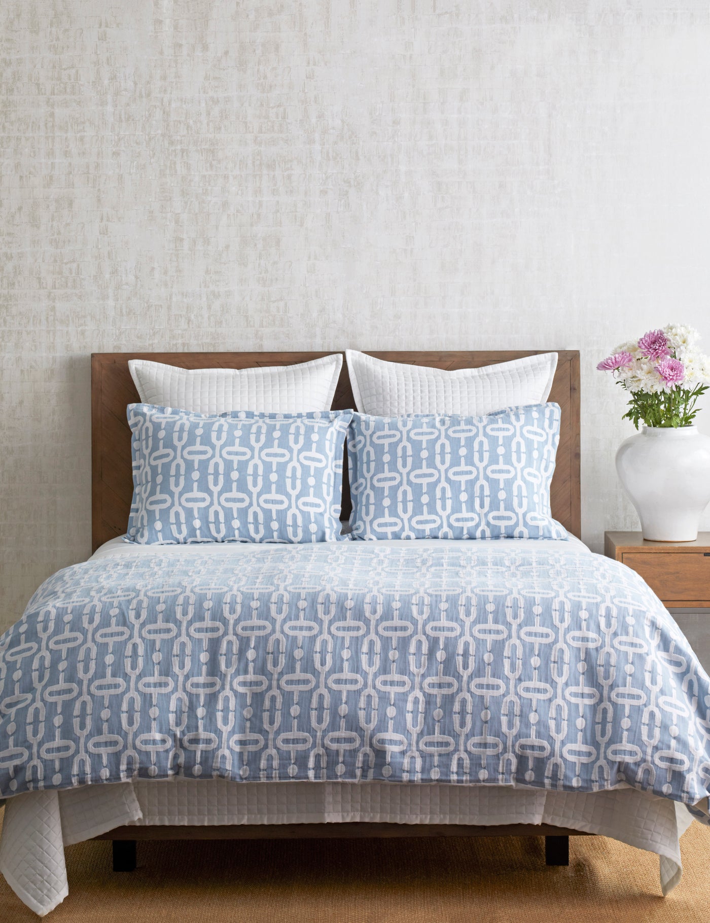 Ann Gish Doorknocker duvet set in blue, styled on a bed with matching shams.