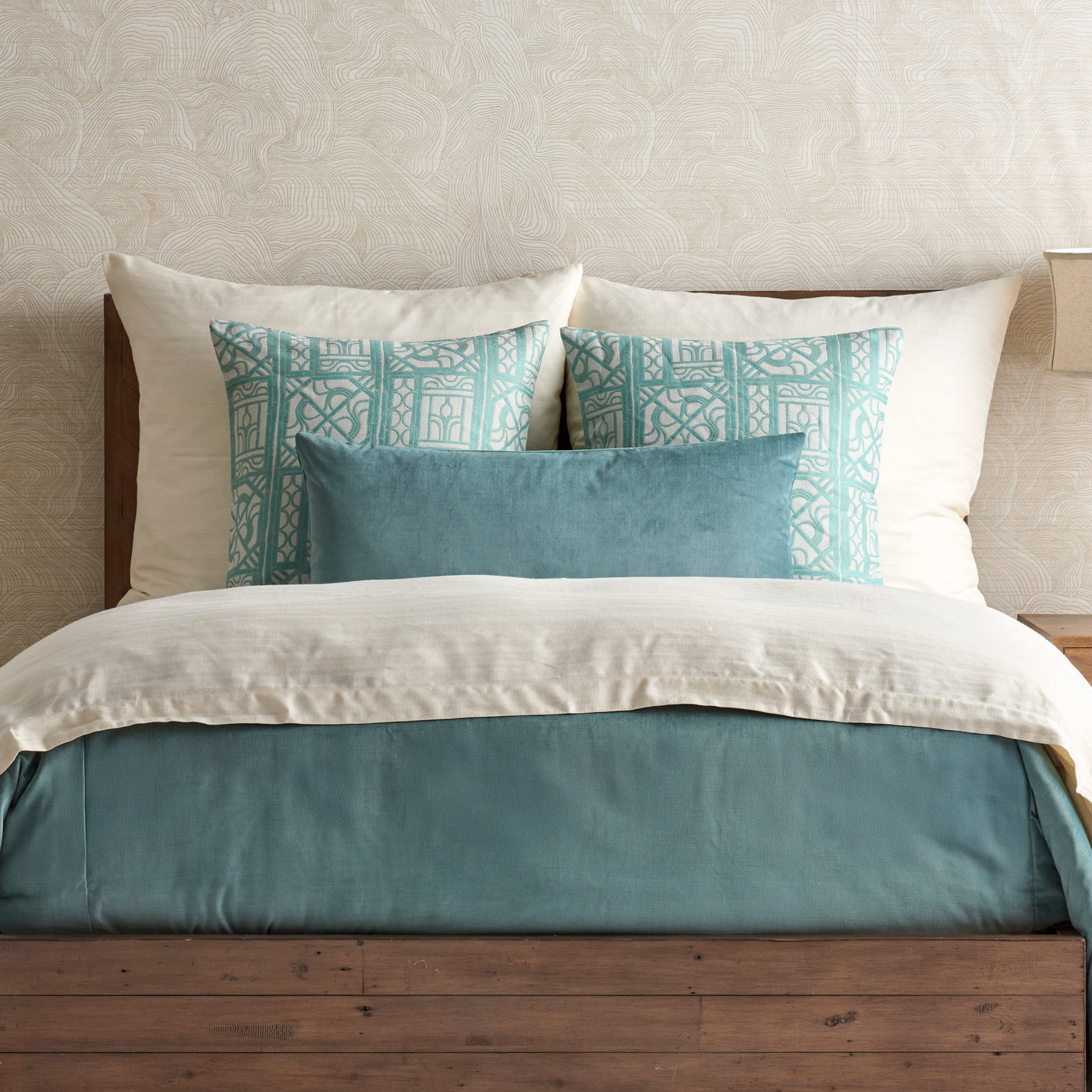 Ann Gish Doria duvet in ivory and teal, styled on a bed with coordinating pillows.