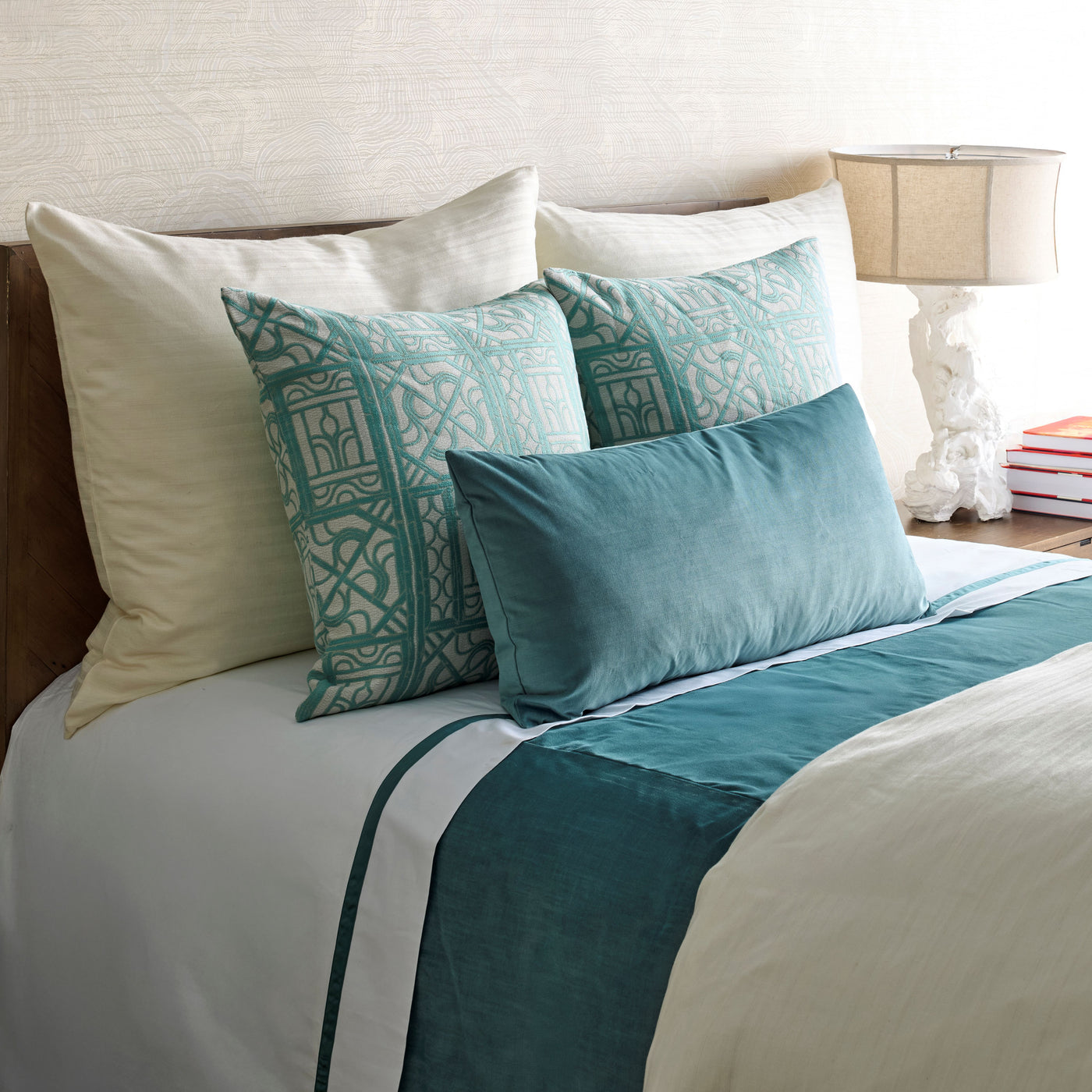 Ivory duvet styled with teal velvet lumbar pillow, patterned shams, and matching bed runner.