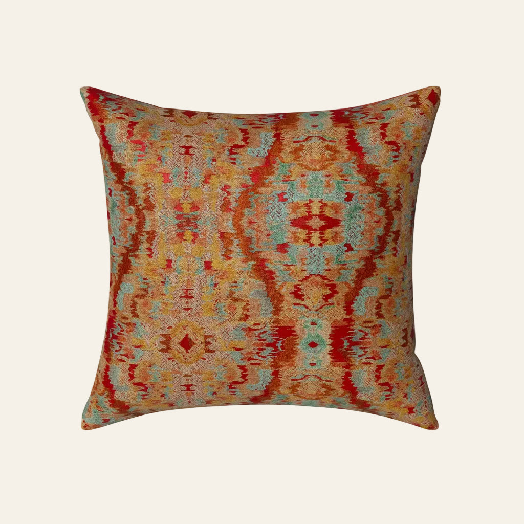 Ann Gish Dowry pillow with multicolor ikat pattern in crimson, amber, and aqua.