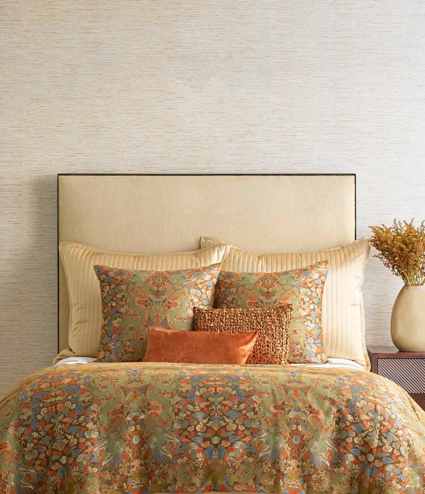 Styled bed showing Ann Gish Dragon duvet in amber floral tapestry with terracotta accent pillows.