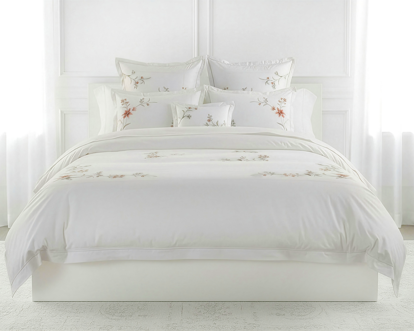 Close-up of floral embroidery detail on ivory Henry Handwork Eden cotton bedding.