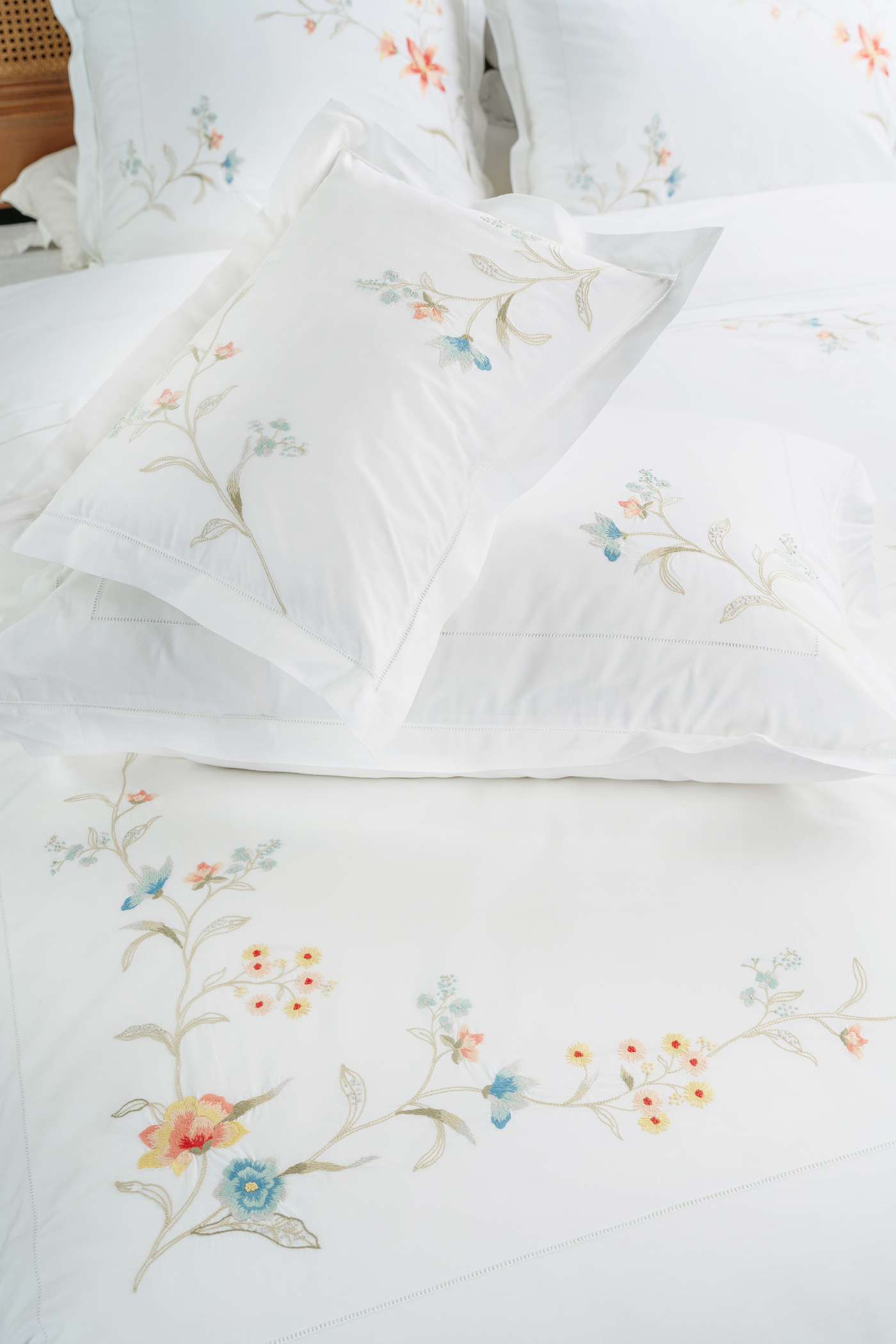 Close-up of Eden embroidered flat sheet with multicolour floral motif on white cotton.