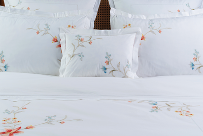 Floral embroidered pillows and duvet set on a bed