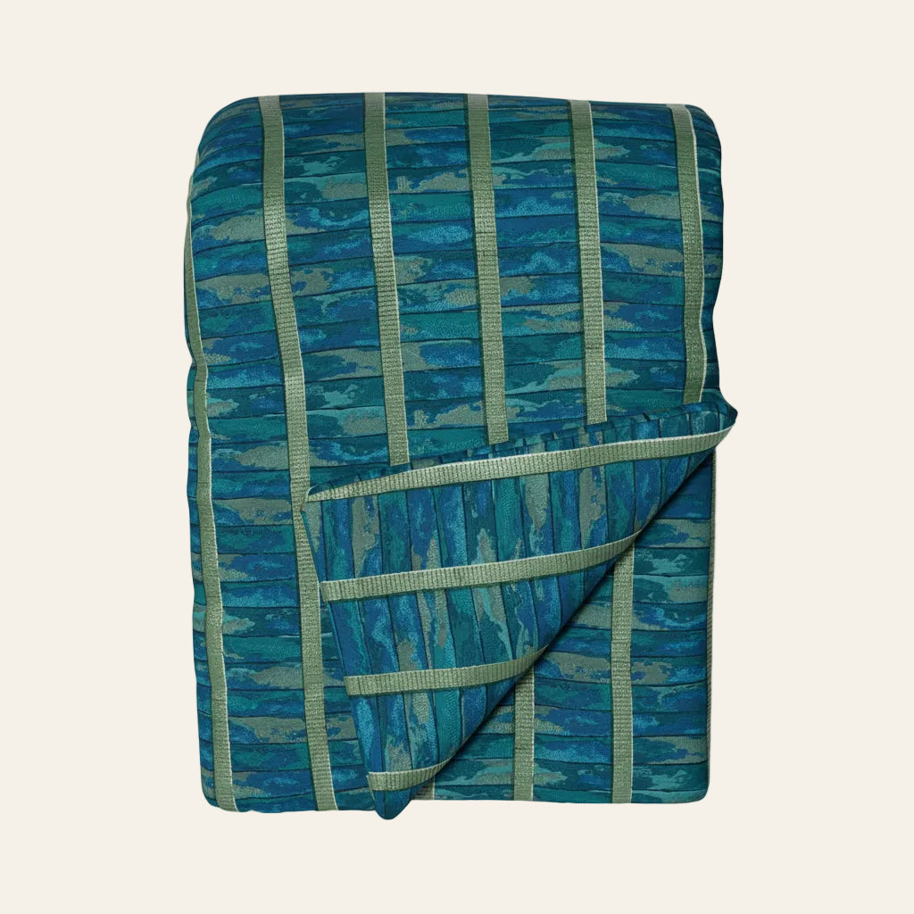 Ann Gish Egyptian Faience throw, folded, teal and sage striped quilted fabric.