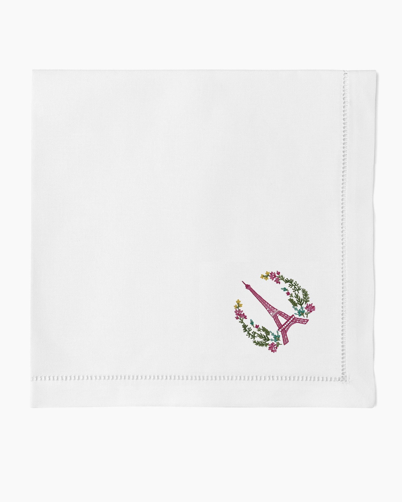 Henry Handwork white linen dinner napkin with embroidered Eiffel Tower and floral wreath.