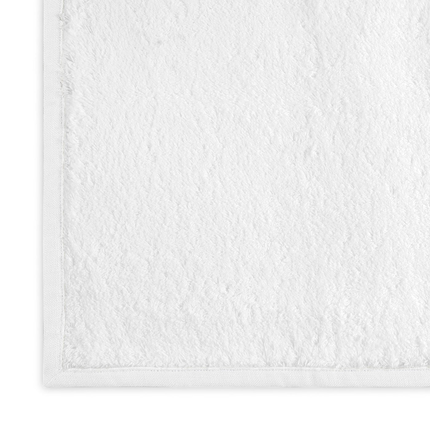 Close-up of white terry cloth texture with smooth woven border on Matouk Enzo bath towel.
