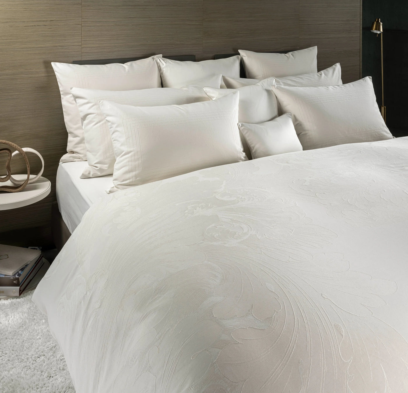 Ivory jacquard duvet cover with swirling tonal pattern, layered with champagne pillows.