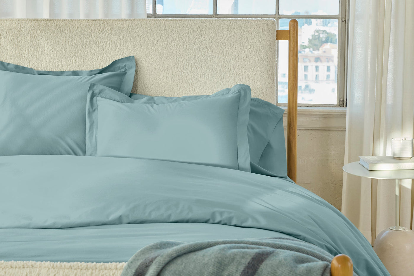 Refined Percale shams in spa blue styled on a made bed with natural light.