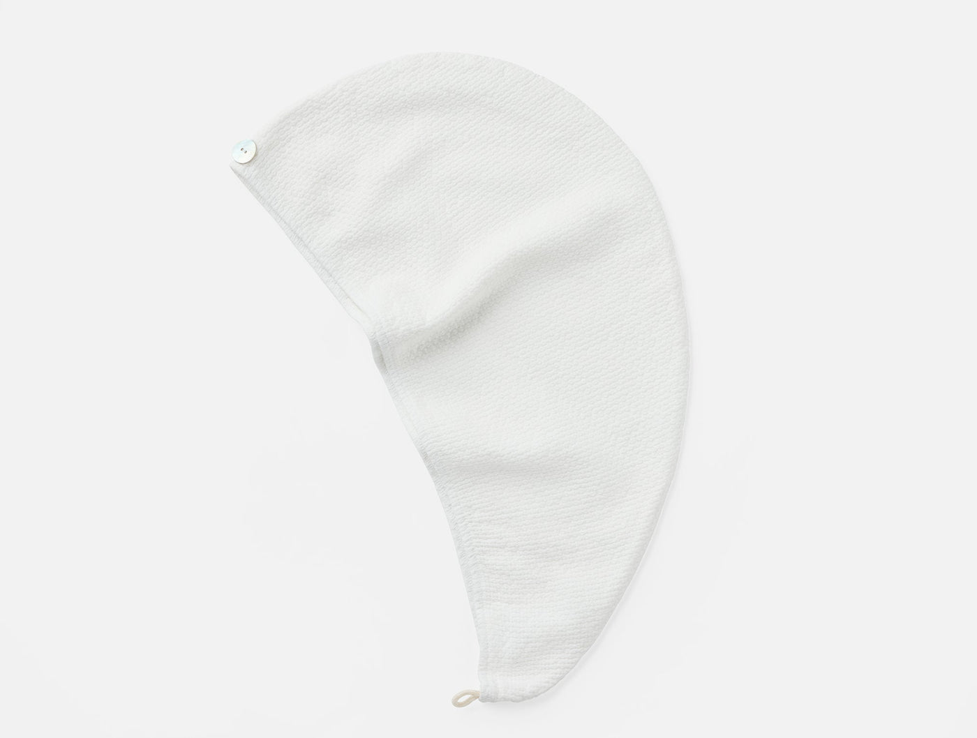 Coyuchi Adriatic hair wrap in white, flat lay showing loop closure and textured weave.