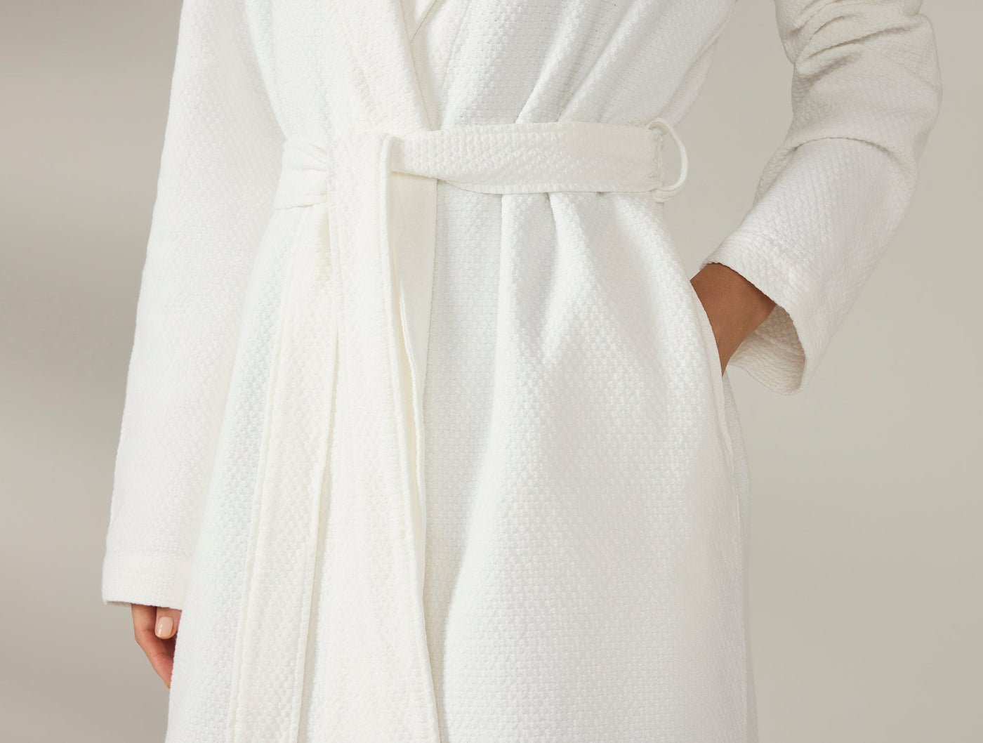 Close-up of ivory waffle-weave robe belt and pocket detail.