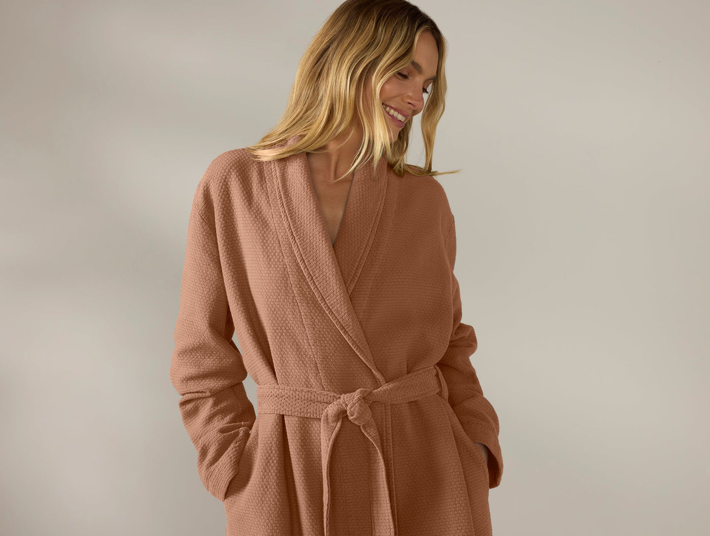 Back view of Coyuchi Adriatic robe in terracotta, showing belted waist and textured weave.