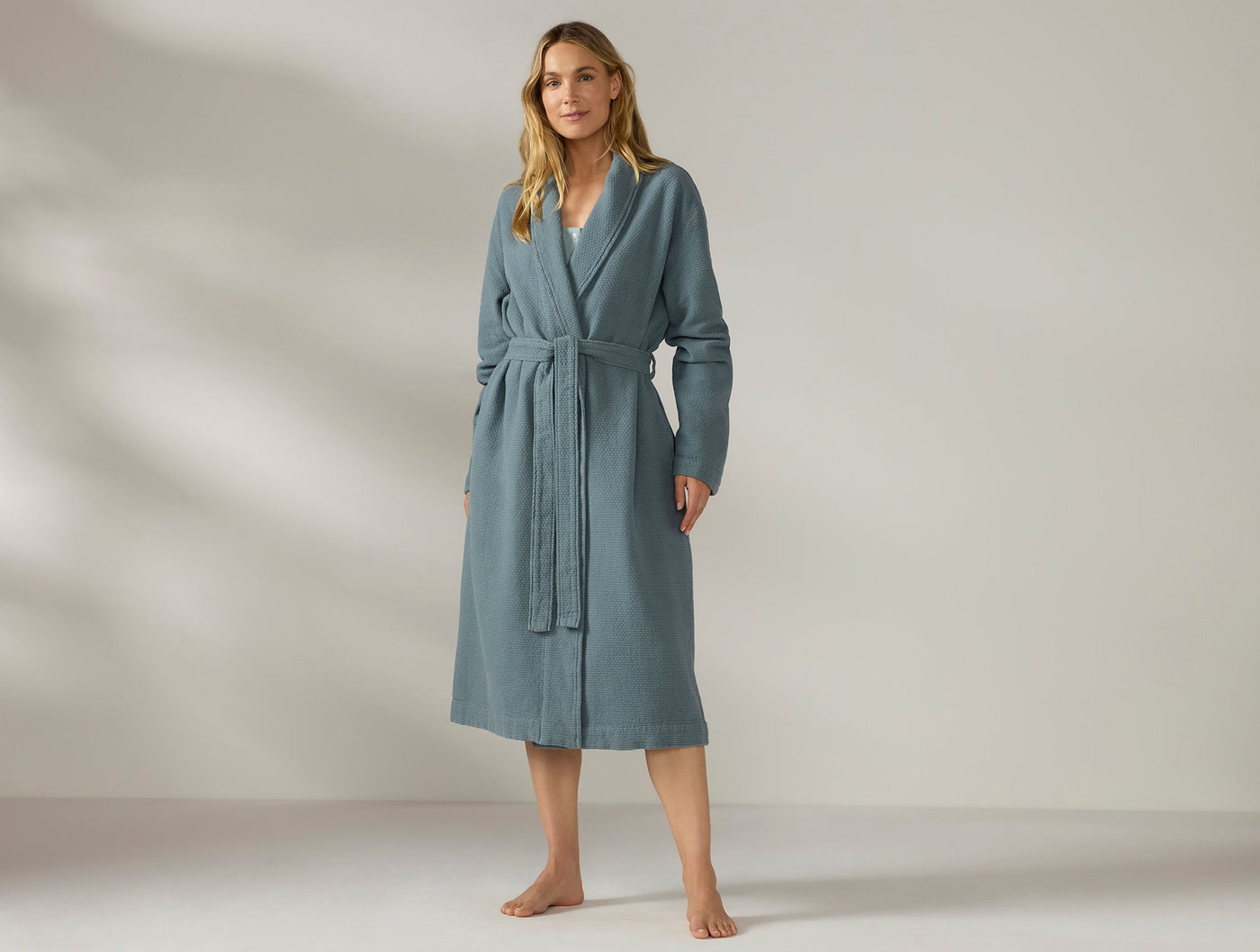 Coyuchi Adriatic robe in slate blue, belted and worn full-length on a standing model.