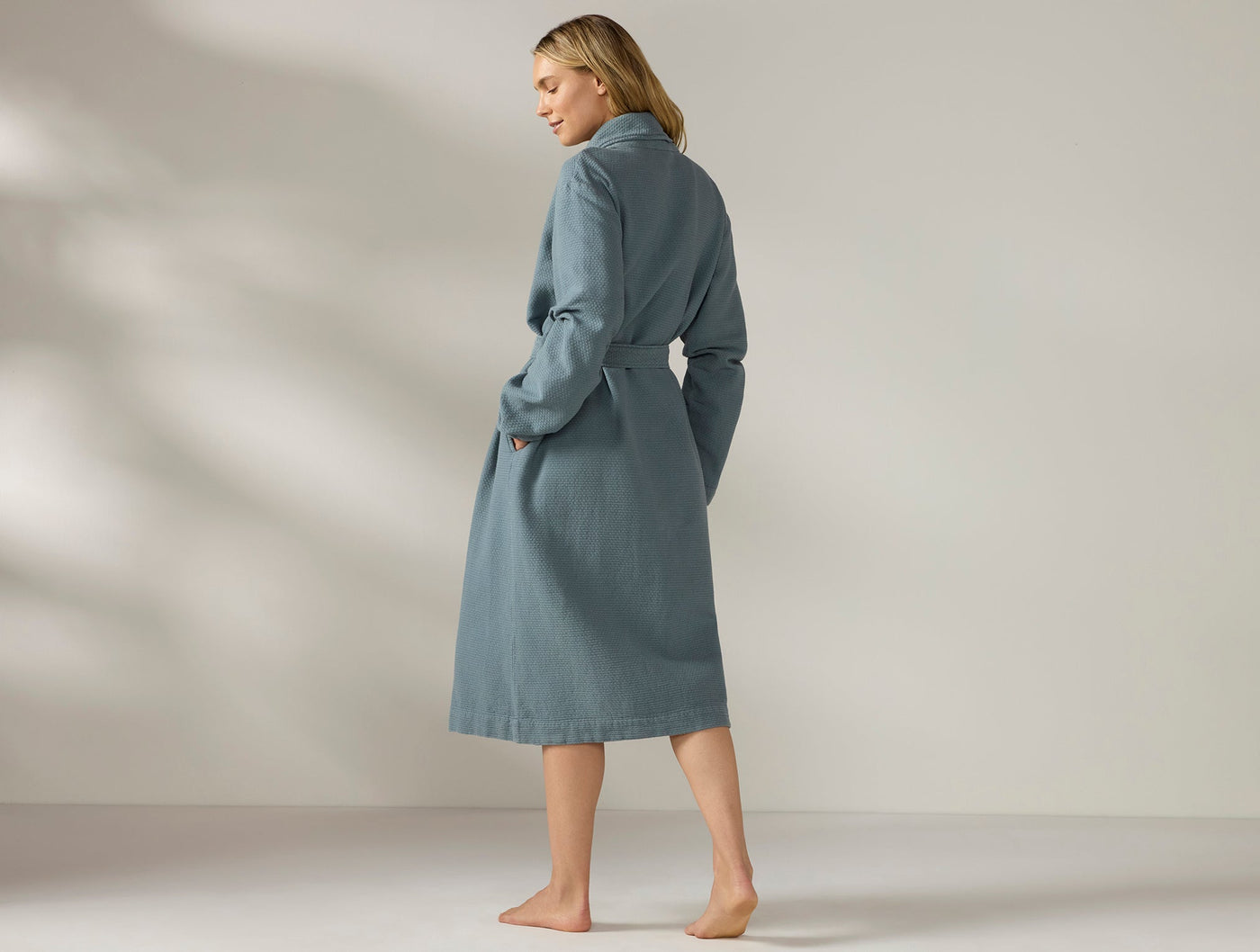 Rear view of Coyuchi Adriatic robe in slate blue, belted waist, mid-calf length.