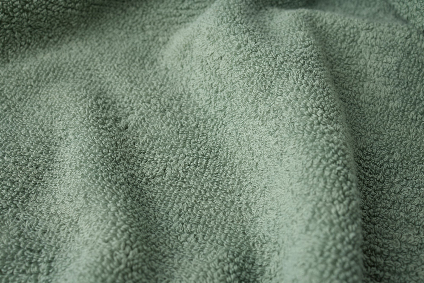 Close-up of sage green terry cloth texture on Coyuchi Air Weight wash cloth.